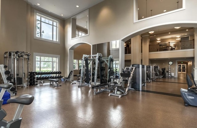 exercise room featuring a towering ceiling