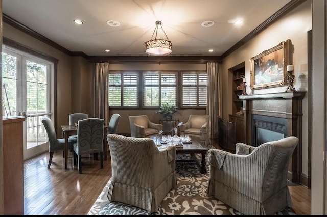 sitting room featuring ornamental molding, plenty of natural light, and wood-type flooring