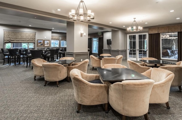 carpeted dining area featuring crown molding, french doors, and a chandelier