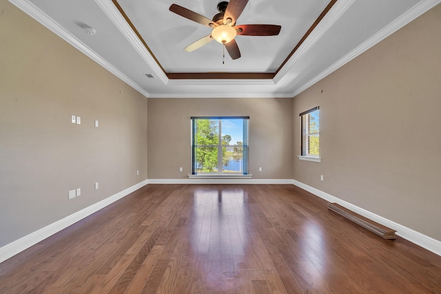 spare room with hardwood / wood-style floors, ceiling fan, a raised ceiling, and ornamental molding