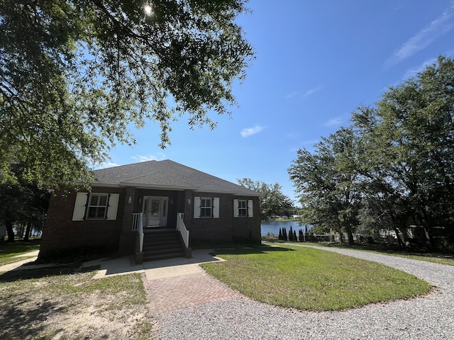 view of front of property featuring a water view and a front lawn