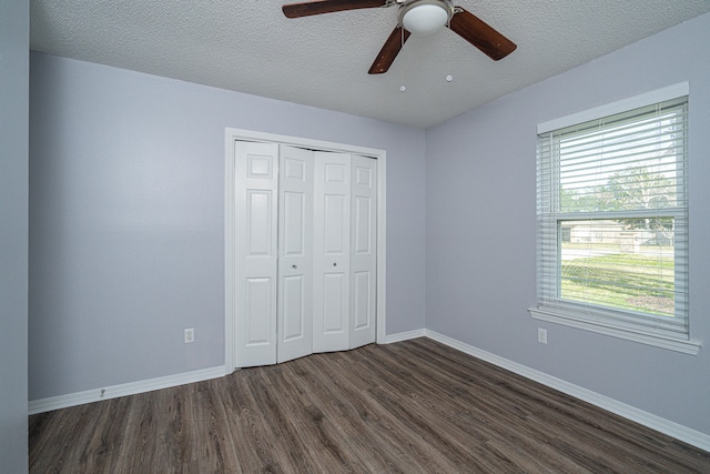 unfurnished bedroom with a closet, dark hardwood / wood-style flooring, ceiling fan, and a textured ceiling