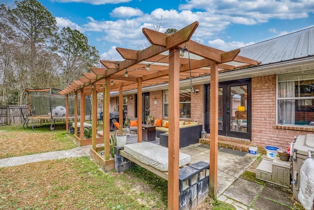 wooden deck featuring a trampoline, a patio area, outdoor lounge area, and a lawn