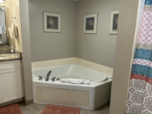 bathroom featuring tile patterned flooring, vanity, and a tub