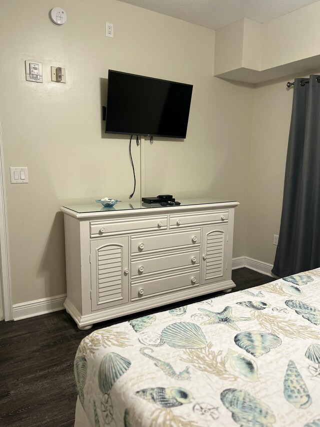 bedroom with dark hardwood / wood-style floors