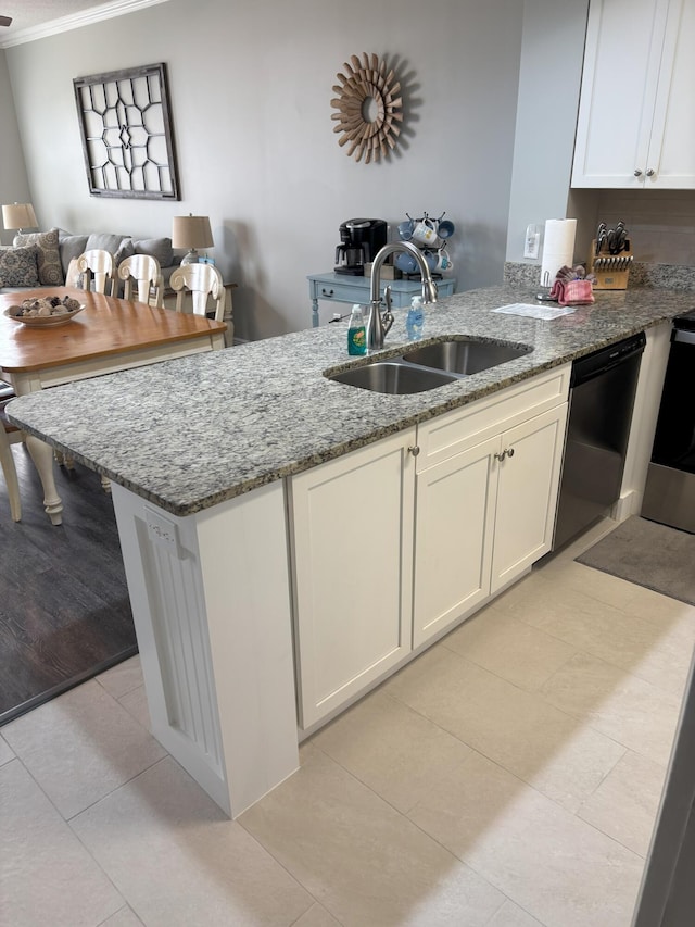 kitchen with light stone counters, sink, light tile patterned flooring, and black dishwasher