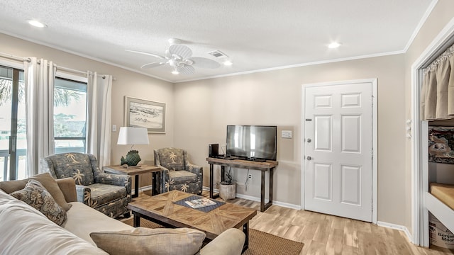 living room with ceiling fan, crown molding, light wood-type flooring, and a textured ceiling