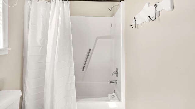 bathroom with toilet and shower / bath combo with shower curtain