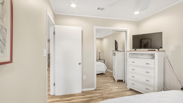 bedroom featuring ornamental molding, light hardwood / wood-style flooring, ceiling fan, and a closet