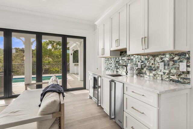 kitchen featuring white cabinetry, sink, and decorative backsplash