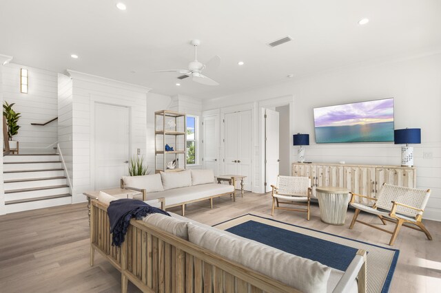 living room with ceiling fan and light hardwood / wood-style flooring