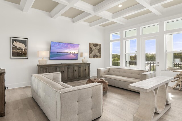 living room with beam ceiling, a high ceiling, coffered ceiling, and light hardwood / wood-style floors