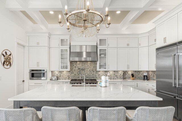 kitchen with a spacious island, stainless steel appliances, a breakfast bar, and wall chimney range hood