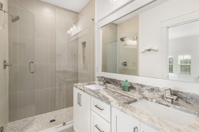 bathroom featuring walk in shower and vanity