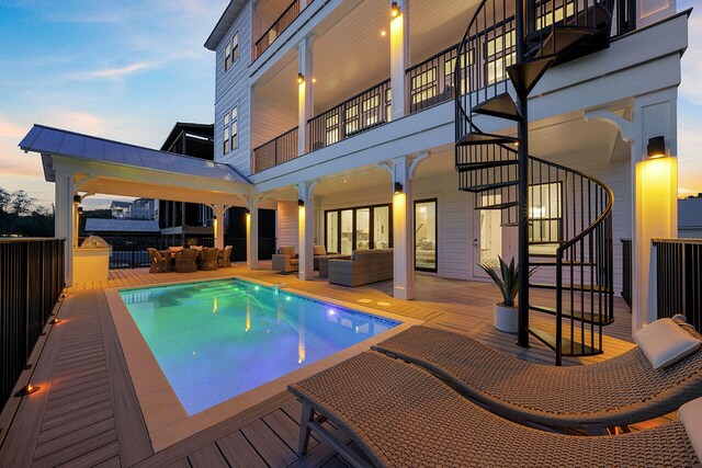 pool at dusk with an outdoor living space