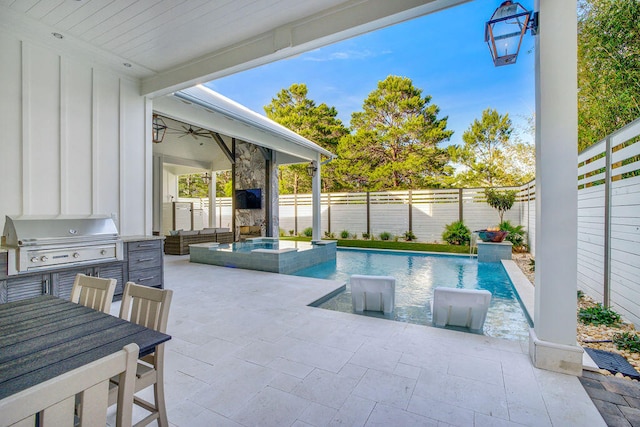 view of swimming pool with a patio, a grill, and an outdoor kitchen