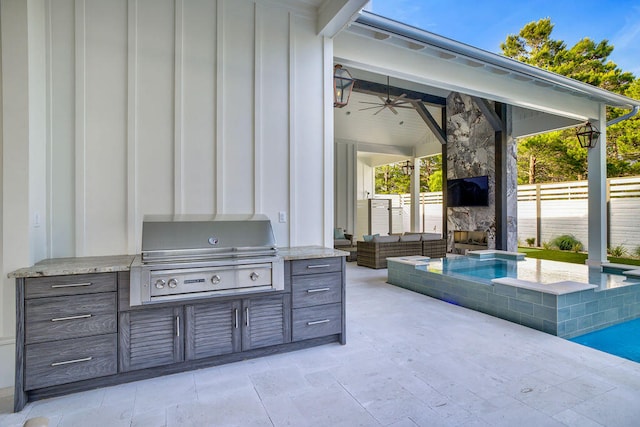 view of patio featuring grilling area, ceiling fan, and exterior kitchen