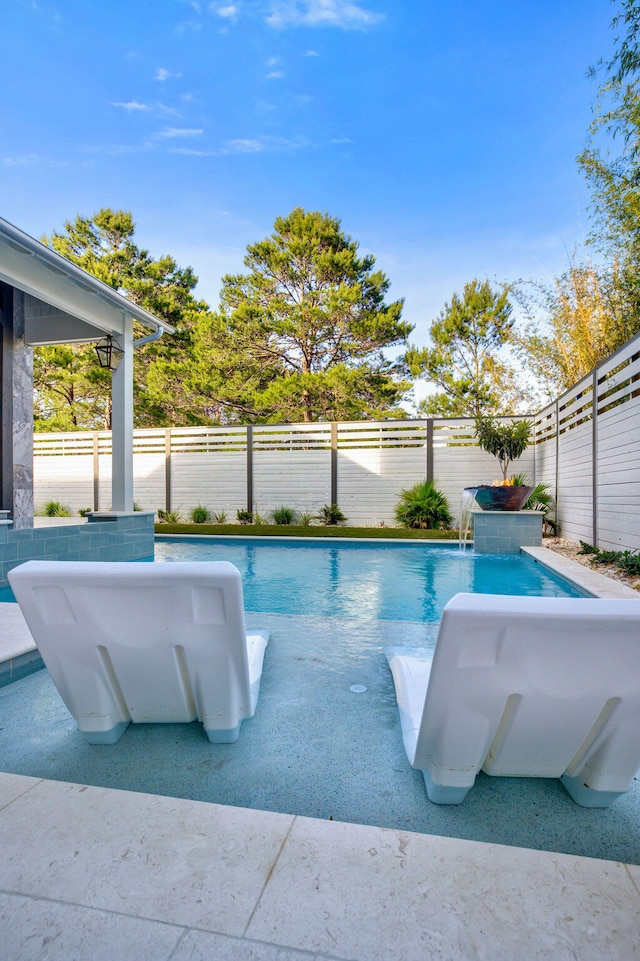 view of swimming pool with pool water feature