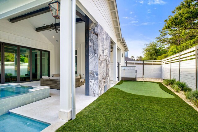 view of yard with a patio, outdoor lounge area, ceiling fan, and a fenced in pool