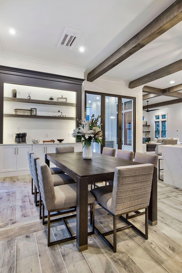 dining space featuring light hardwood / wood-style floors and beam ceiling