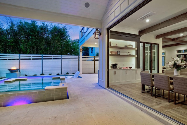 patio terrace at dusk featuring a hot tub