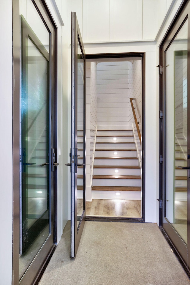 staircase featuring light colored carpet