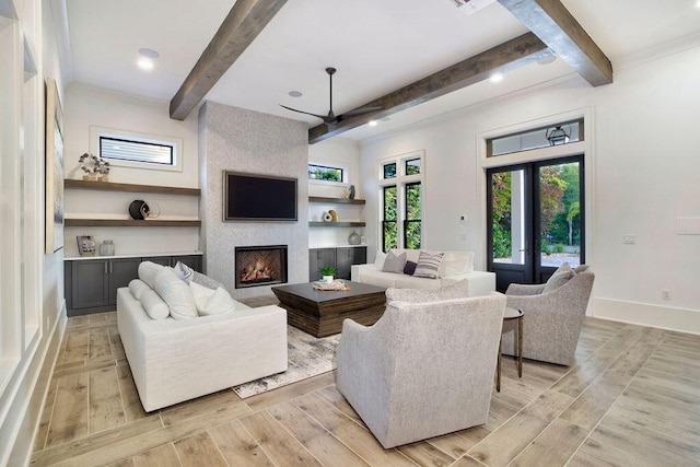 living room featuring a large fireplace, french doors, light hardwood / wood-style flooring, beam ceiling, and ceiling fan