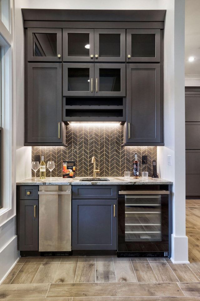 bar with beverage cooler, sink, dishwasher, and tasteful backsplash