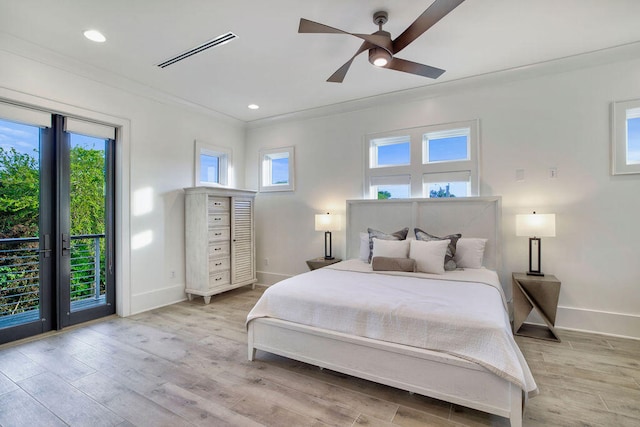 bedroom with light hardwood / wood-style floors, multiple windows, and access to exterior