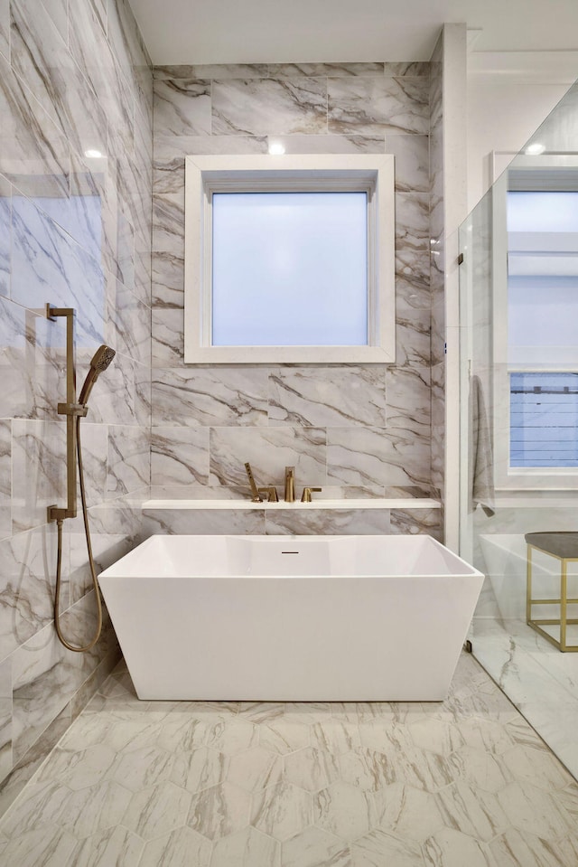 bathroom featuring tile walls, separate shower and tub, and tile flooring