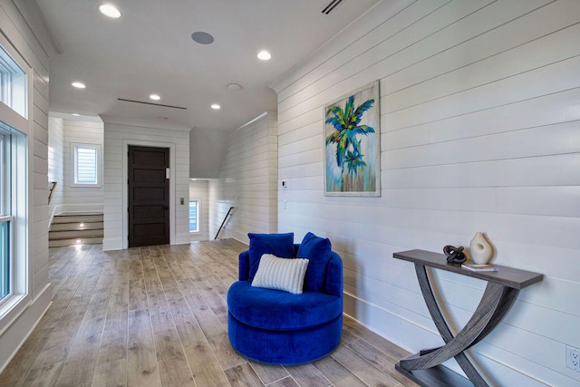 living area featuring wood-type flooring and wooden walls