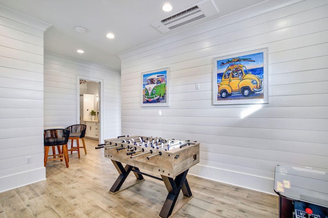 playroom with wood walls and light hardwood / wood-style floors