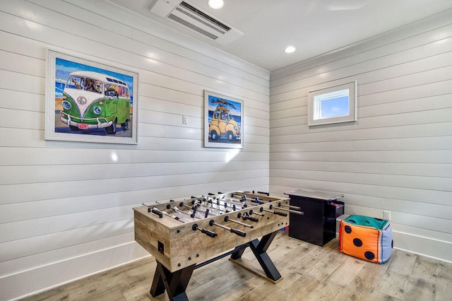 recreation room featuring wood walls and light wood-type flooring