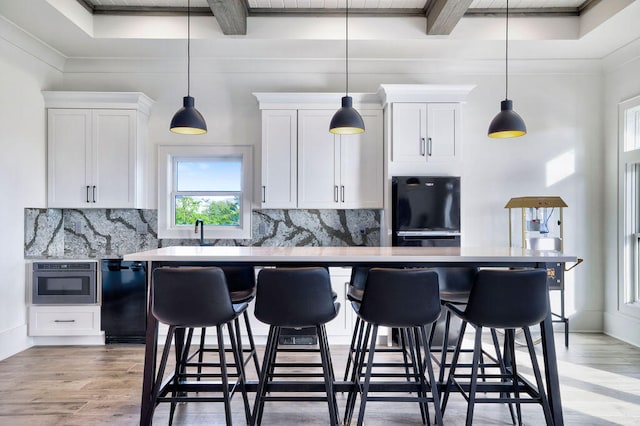 kitchen featuring decorative light fixtures, light hardwood / wood-style flooring, and backsplash