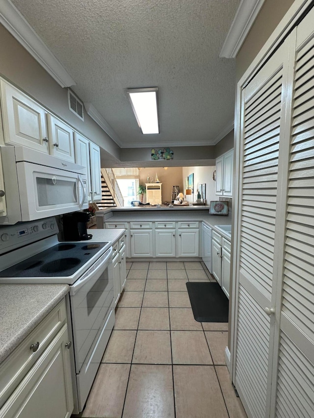 kitchen featuring ornamental molding, white cabinets, white appliances, and light tile flooring