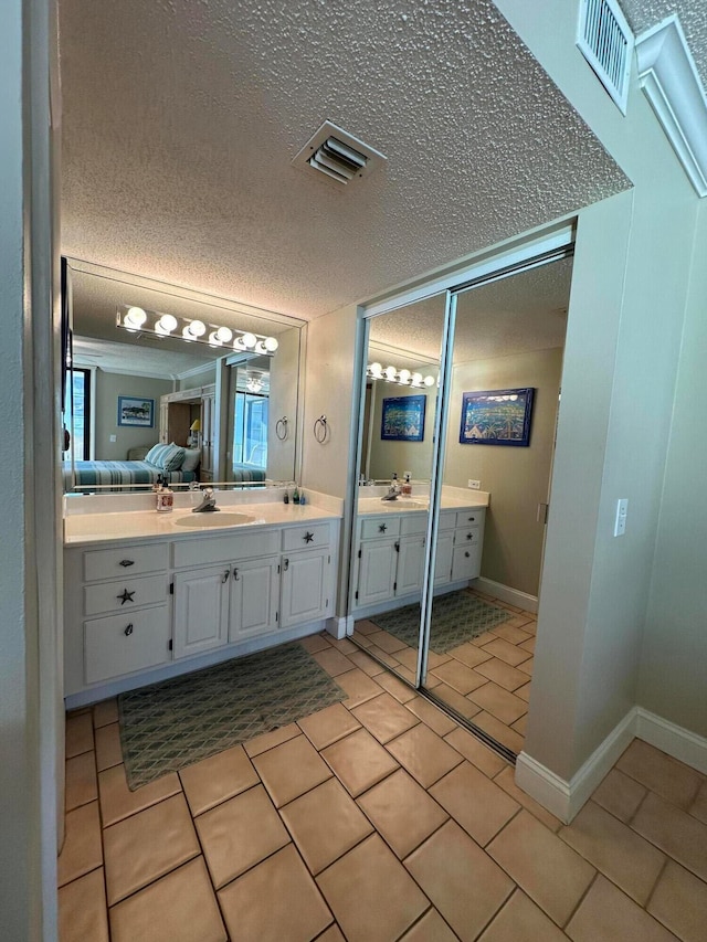 bathroom featuring tile floors, vanity, and a textured ceiling