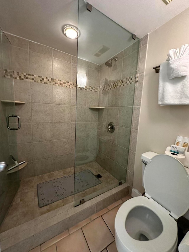 bathroom with walk in shower, toilet, and tile flooring