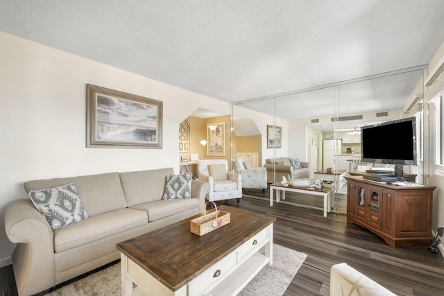 living room with dark hardwood / wood-style flooring and a textured ceiling