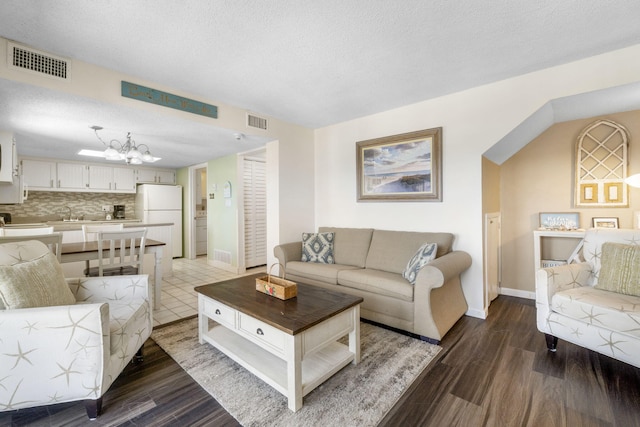 living room with hardwood / wood-style floors, a chandelier, and a textured ceiling