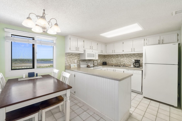 kitchen featuring white appliances, tasteful backsplash, an inviting chandelier, and light tile floors