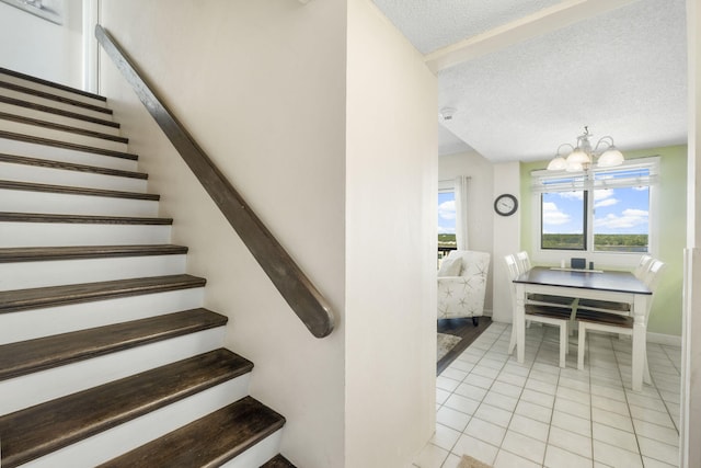 stairs with a chandelier, a textured ceiling, and light tile flooring