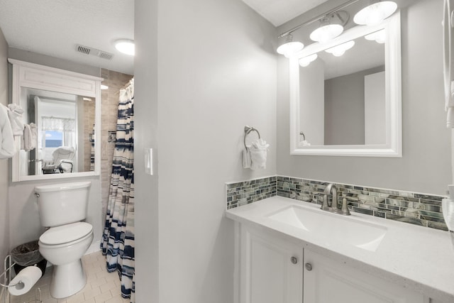 bathroom with tile floors, backsplash, oversized vanity, toilet, and a textured ceiling