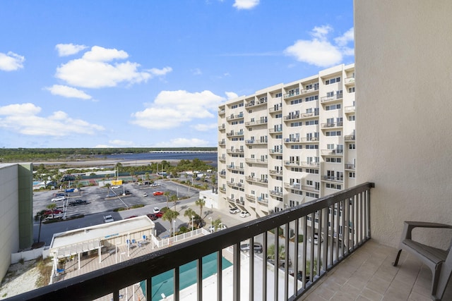 balcony featuring a water view and a community pool