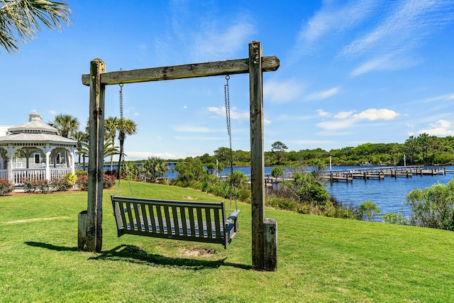 view of nearby features with a boat dock, a lawn, a gazebo, and a water view