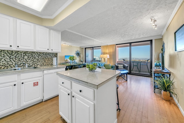 kitchen featuring white cabinets, tasteful backsplash, a center island, and white dishwasher