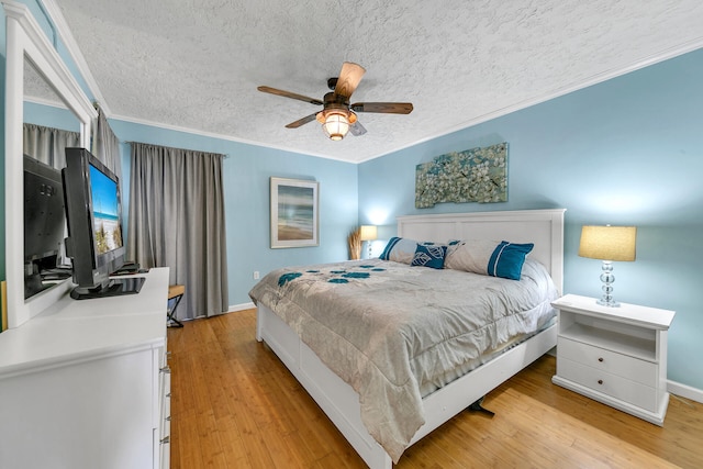 bedroom featuring ornamental molding, light hardwood / wood-style floors, ceiling fan, and a textured ceiling