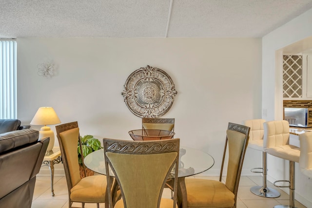 dining area with light tile floors and a textured ceiling