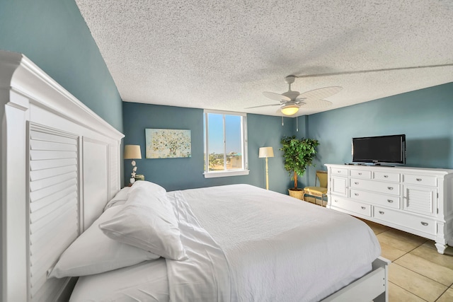 tiled bedroom with a textured ceiling and ceiling fan