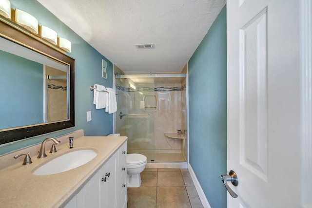 bathroom featuring oversized vanity, toilet, tile flooring, a textured ceiling, and an enclosed shower