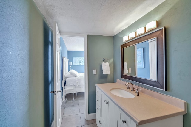 bathroom with tile flooring, vanity, and a textured ceiling